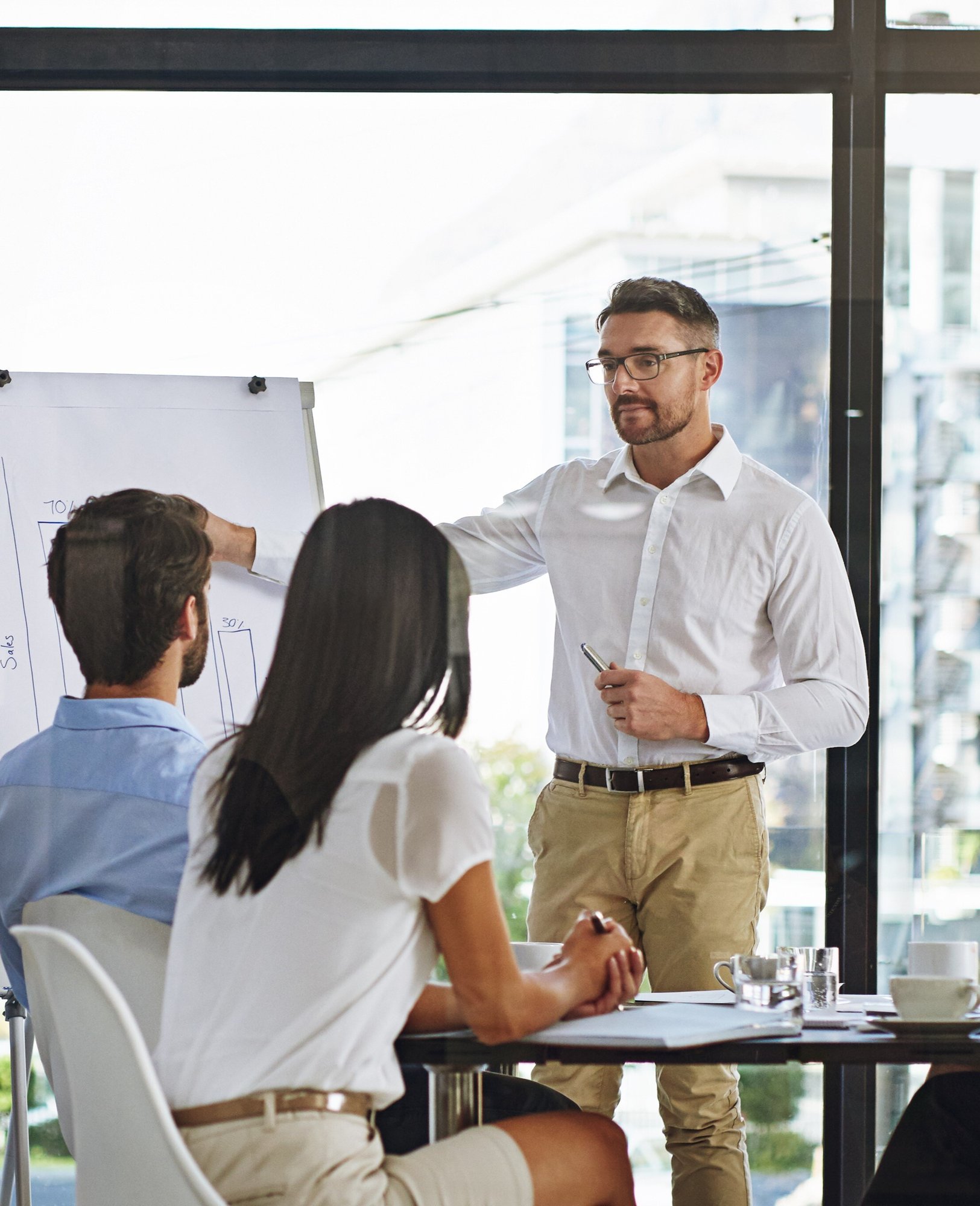 man presents business insights to employees in office
