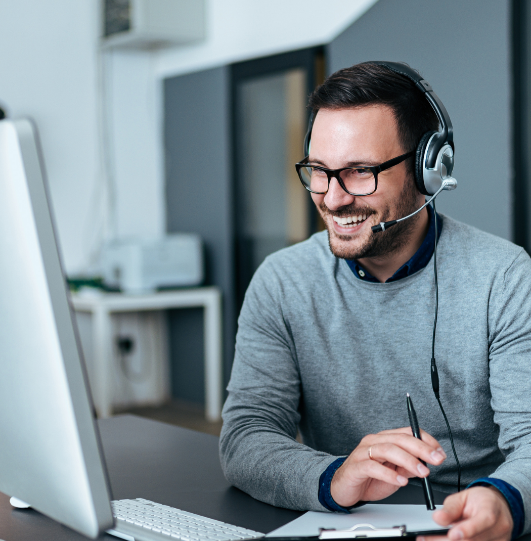 Man in office on headset smiling-1