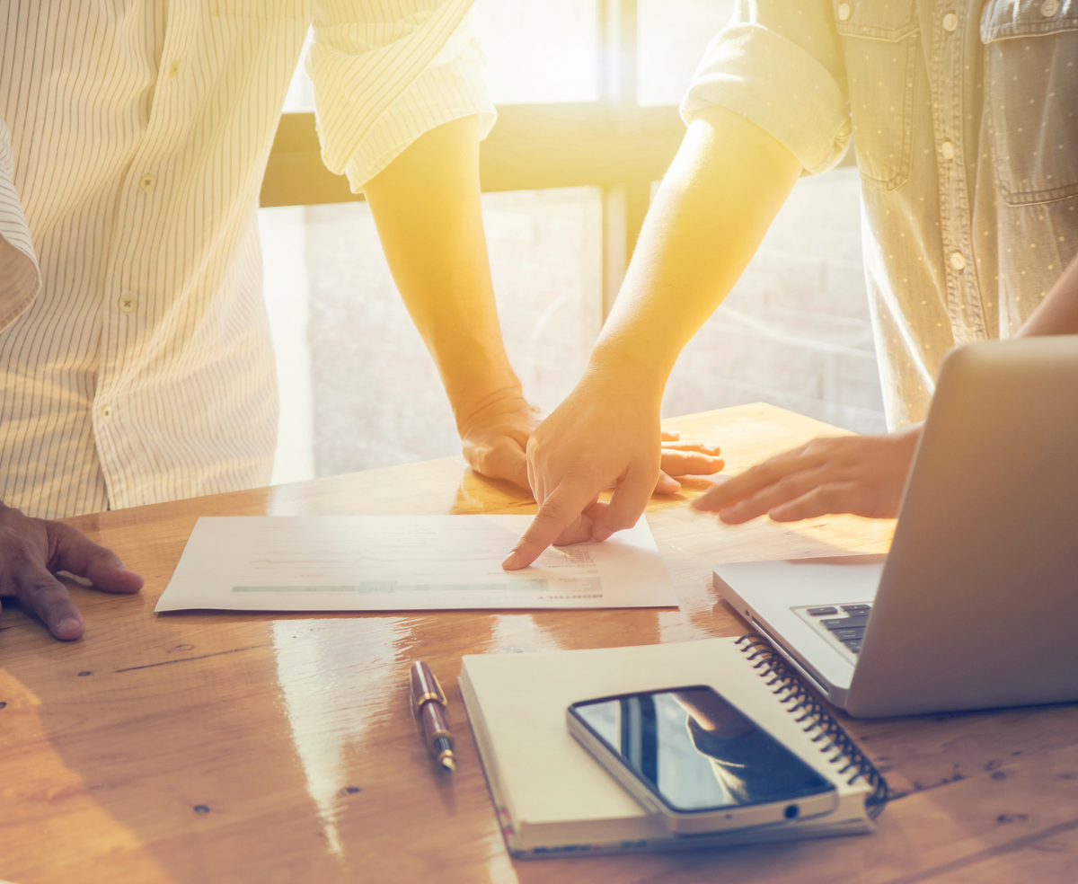 two people looking at document in sunlight