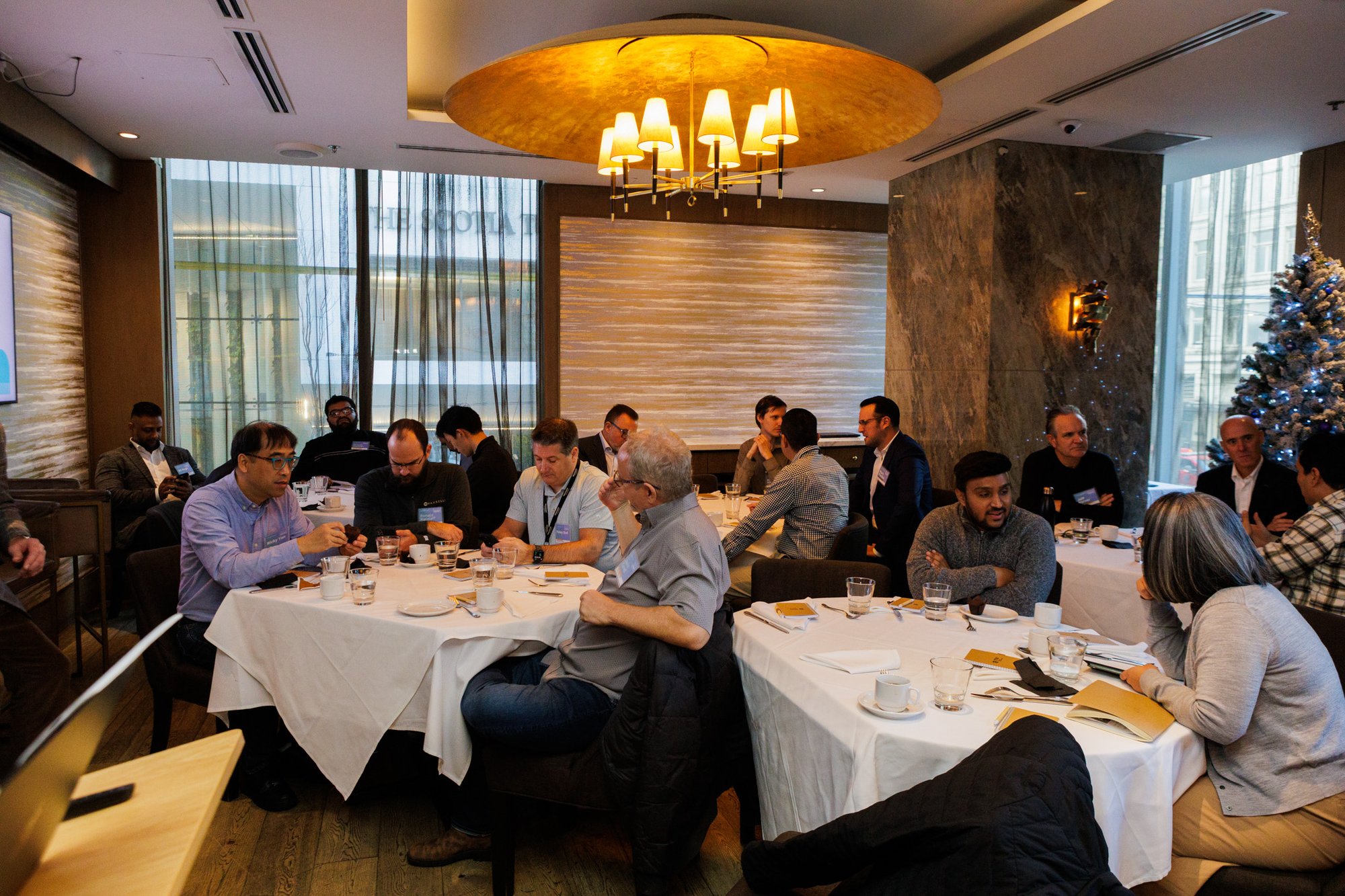 IT Weapons and business professionals gathered around a table at a Vancouver cybersecurity summit event