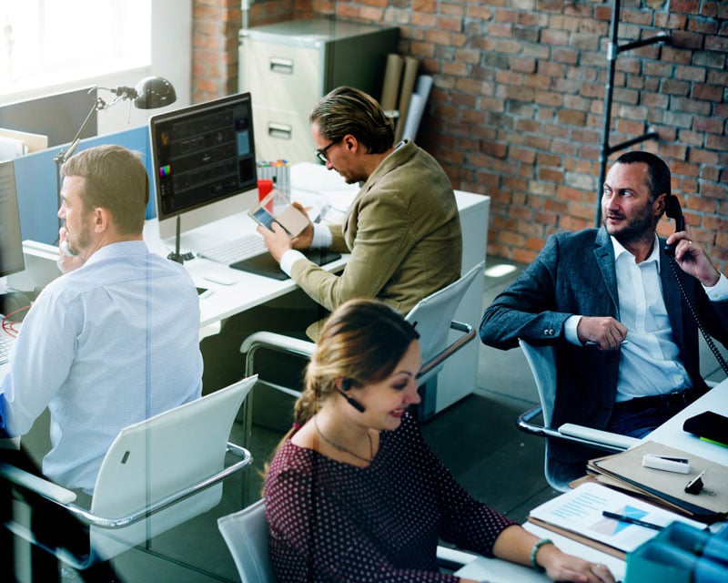 A group of colleagues doing work in an office setting.
