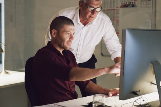 IT professionals working on a desktop computer, providing IT security services to maintain system integrity and protection.