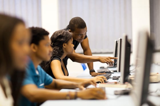 College students working in a computer room, supported by managed IT services to ensure secure and efficient digital learning.