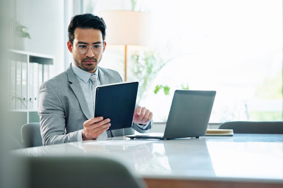 A Finance professional working on several devices, relying on IT security services for seamless protection.