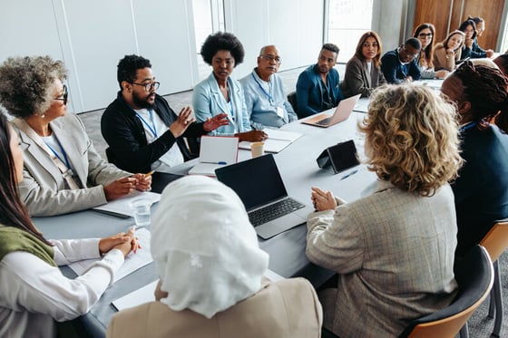 A group of government employees having a meeting in a conference room, discussing IT security solutions for enhanced protection.